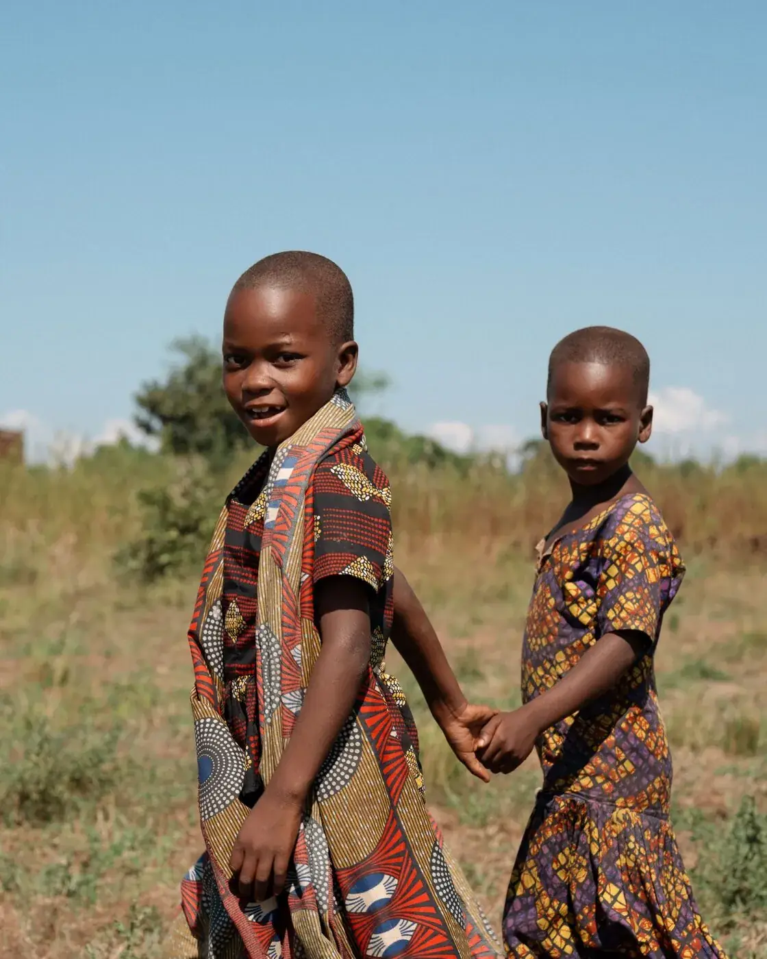 Two children holding hands and smiling