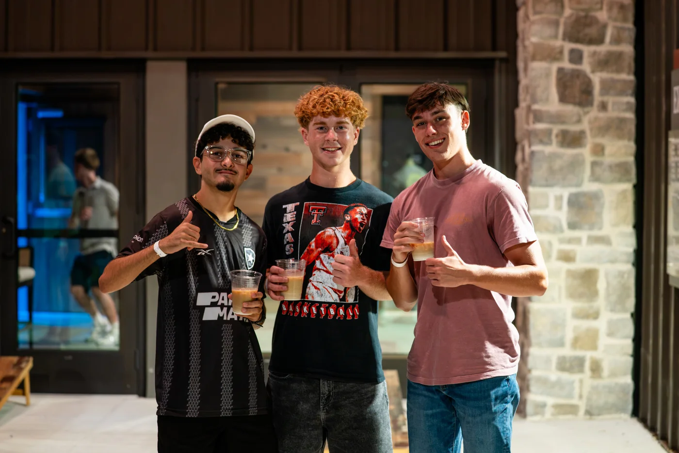 Three students smiling together at a gathering